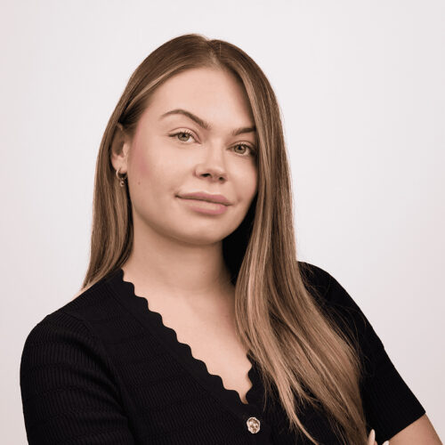 Portrait of Bruno Witek wearing glasses and a striped shirt, seated indoors.